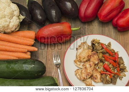 fried chicken with eggplant and vegetables, fresh vegetables
on the table