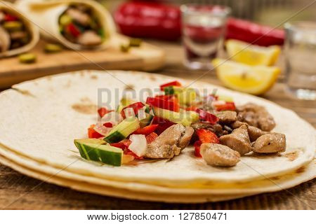 Traditional mexican tortila wrap with meat and vegetables