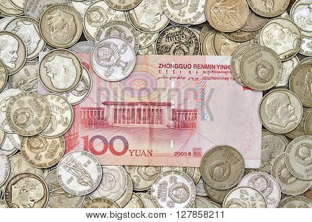 Photo of one hundred yuans lying on heap of old coins. Currency exchange illustration