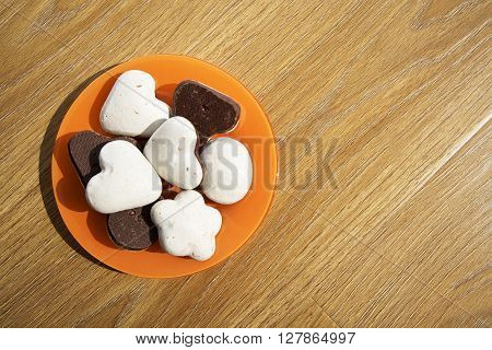 Cookies in an orange plate on a wooden table