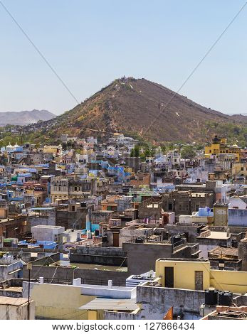 A view over rooftops in central Udaipur during the day. The Machla Hills can be seen in the distant.