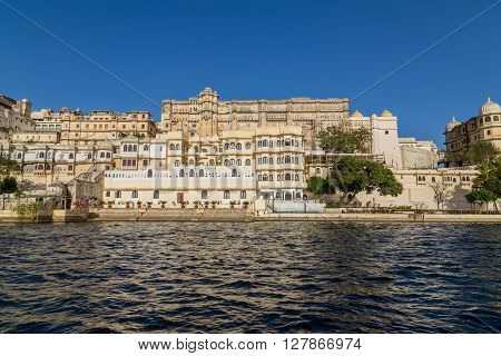 UDAIPUR INDIA - 20TH MARCH 2016: Part of the city palace in Udaipur during the day from the lake.