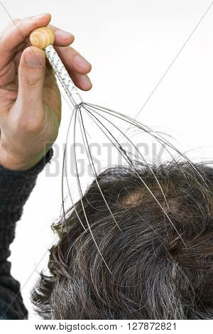 Man relaxes with the Genie head massager. Alternative Therapy. Indian head massage tool self head massager.
