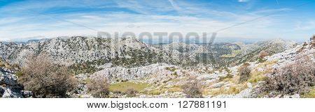 Panorama of sunny remote landscape under blue sky with white clouds
