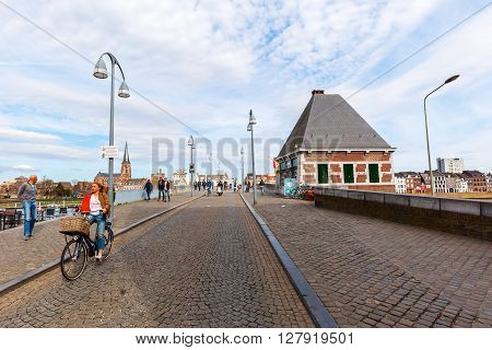 Maastricht Netherlands - April 11 2016: bridge over the river Meuse in Maastricht with unidentified people. Maastricht is a university city and the capital of the Dutch province Limburg