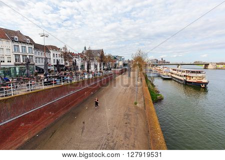 Maastricht Netherlands - April 11 2016:cityscape of Maastricht along the river Meuse with unidentified people. Maastricht is a university city and the capital of the Dutch province Limburg
