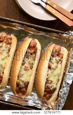 Baked chili hot dogs in baking pan photographed overhead with natural light