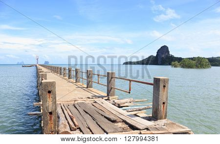 old wooden and concrete bridge to dock pier in tranquil sea to find destination wayTrang Thailand