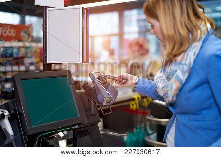 Young Woman Making Self-checkout In Supermarket With Mobile Phone