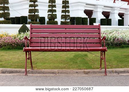 A Red Wooden Bench In The Park