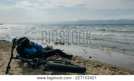 Fat Bike Also Called Fatbike Or Fat-tire Bike In Summer Driving On The Beach. The Guy Sits On The Wh