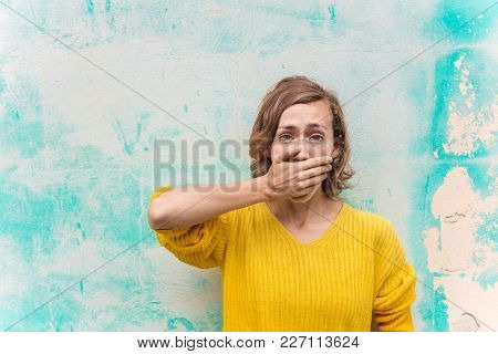 Spellbound woman covering her mouth