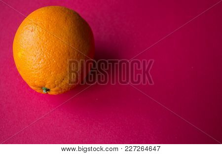 Ripe Orange On A Red Background
