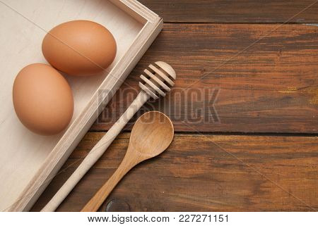 Raw Eggs With Wooden Spooon And Baking Tools. Bake Or Food Background. Dark Rustic Wooden Background