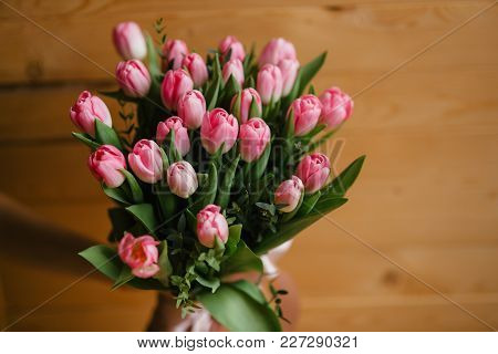 Bouquet Of Pink Tulips With A Beautiful Bow On A Wooden Background.