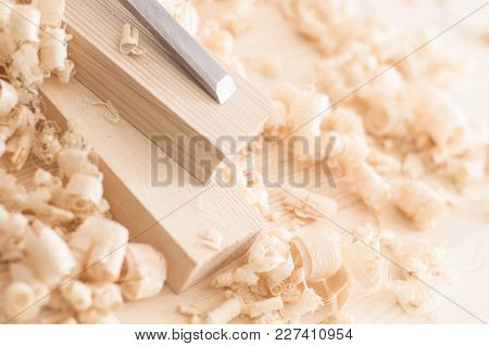 Handmade Woodwork: A Small Red Plane And Chisel On The Boards In Shavings