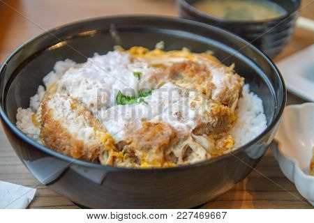 Katsudon Japanese Food, A Bowl Of Rice Topped With A Deep-fried Pork Cutlet, Egg, Vegetables, And Co