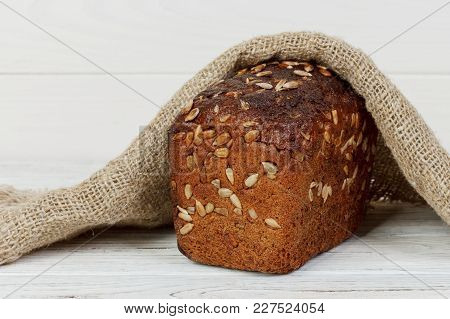 Traditional Round Rye Bread On White Wooden Table.