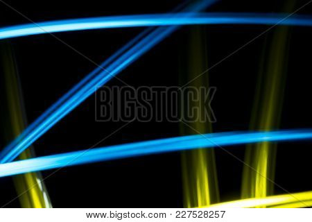 Light Effect Background. Multicolored Luminous Tracks In The Dark. Yellow And Blue. In The Form Of A