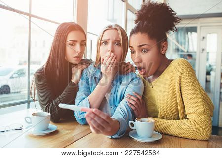 Blonde Girl Is Holding A Pregnancy Test That Shows To Her Positive Result Of The Test. She Looks Dis