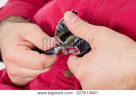 Male Airline Passenger Unbuckling His Seatbelt Buckle Lifting The Lever With His Thumb As He Pulls T