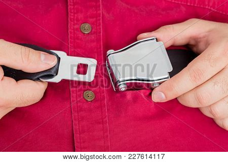 Male Airline Passenger Unbuckling His Seatbelt Buckle Lifting The Lever With His Thumb As He Pulls T