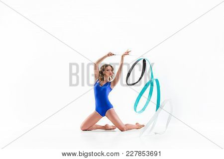 The Portrait Of Beautiful Young Brunette Woman Gymnast Training Calilisthenics Exercise With Blue Ri