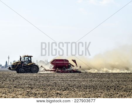 Russia, Temryuk - 19 July 2015: Tractor Rides On The Field And Makes The Fertilizer Into The Soil. C