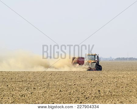 Russia, Temryuk - 19 July 2015: Tractor Rides On The Field And Makes The Fertilizer Into The Soil. C