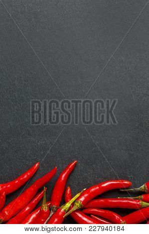 Fresh Ripe Red Hot Chili Peppers On A Black Stone Background
