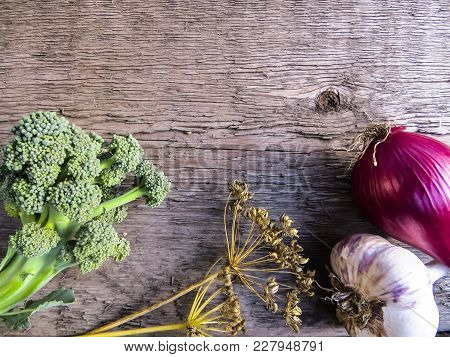 Vegetables  From Organic Grower Farm On A Wooden Background.garlic, Onion And Broccoli.top View. Pla