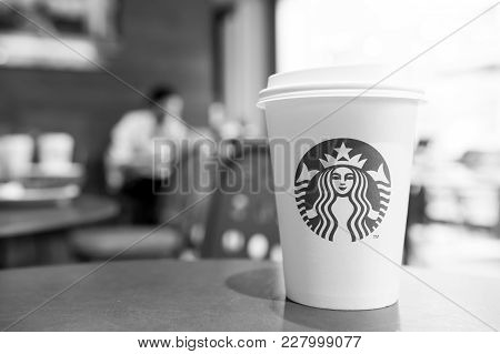 A Tall Starbucks Coffee Cup In Starbucks Offee Shop.