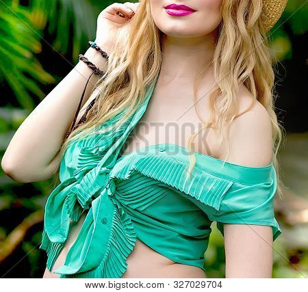 Pregnant Blond Girl In White Trousers And A Green Blouse In The Tropics Walks