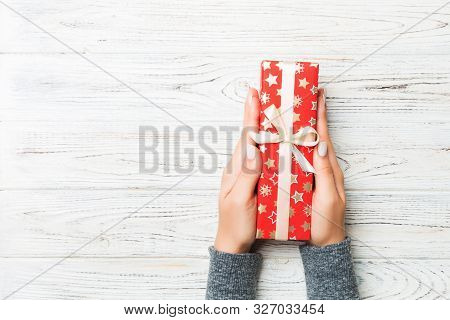Top View Woman Hands Holding Present Box With Colored Bow On White Rustic Wooden Background With Cop