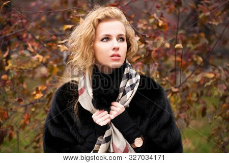 Russian girl. Portrait of beautiful young blonde woman in neckerchief, autumn park outdoors