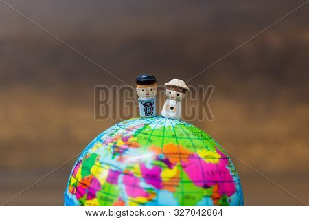 Miniature Toy : Wooden Doll With The Globe  On Wooden Background