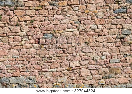 Fragment Of The Fortress Wall Of Pink Stones. Stones Of Various Shapes Are Carefully Adjusted To Eac