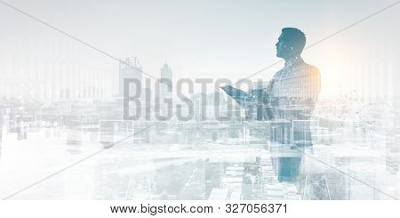 serious thoughtfull businessman writing in notebook against a cityscape background