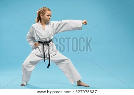 Pretty, Young Girl Practicing Karate And Jujitsu. Confident Junior Wearing In White Kimono With Blac