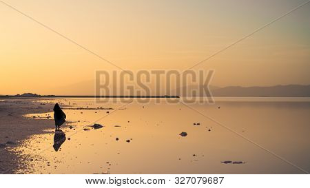 Silhouette And Reflection Of An Unidentified Iranian Woman In Hijab Burka Near Maharloo Pink Lake In