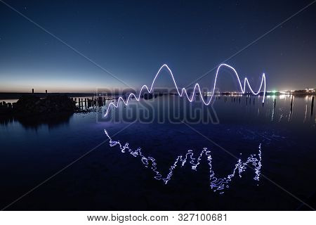 Amazing Laser Fireshow Performance In The Night Blue Sky With Reflections In The Sea Water