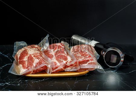 Sous Vide Cooker Immersion Circulator And Meat On A Dark Background.