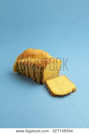 Home-baked Yellow Corn Bread, Cut In Slices, On Blue Background. European Cornbread Recipe. Freshly 