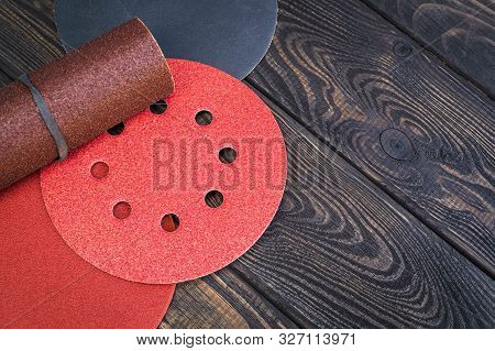Set Of Abrasive Tools And Sandpaper Different Colors On Black Vintage Wooden Background