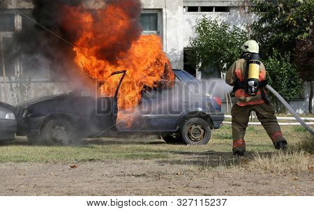 Firefighters Participate In A Training Where They Extinguish Fire From A Car Crashed Into Another Ve
