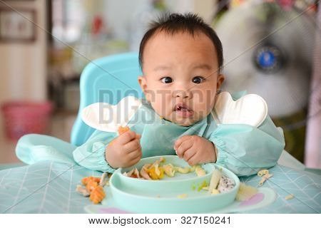 Asian Baby Boy 7 Months Old Eating With Baby Led Weaning (blw) Method, Self-feeding