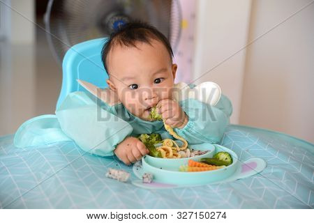Asian Baby Boy 7 Months Old Eating With Baby Led Weaning (blw) Method, Self-feeding