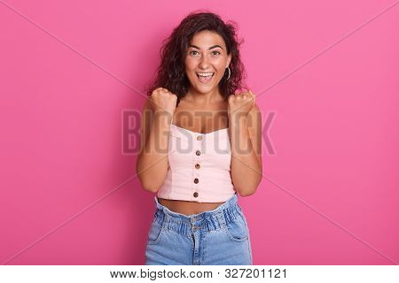 Photo Of Happy Young Woman With Beautiful Dark Wawy Hair Screaming And Clenching Fist While Looking 