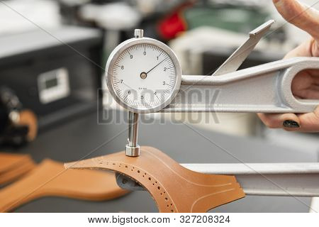 Woman Hands Use Leather Thickness Gauge On With A Natural Brown Leather. Preparing Of The Raw Materi
