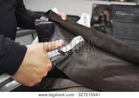 Mens Hands Use Leather Thickness Gauge On With A Natural Brown Leather. Preparing Of The Raw Materia
